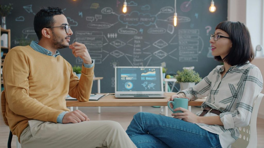 Two colleagues discussing ideas in a modern office.